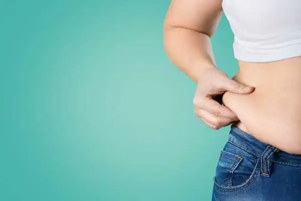 Image of woman pinching her love handles to show weight gain Chapeltown